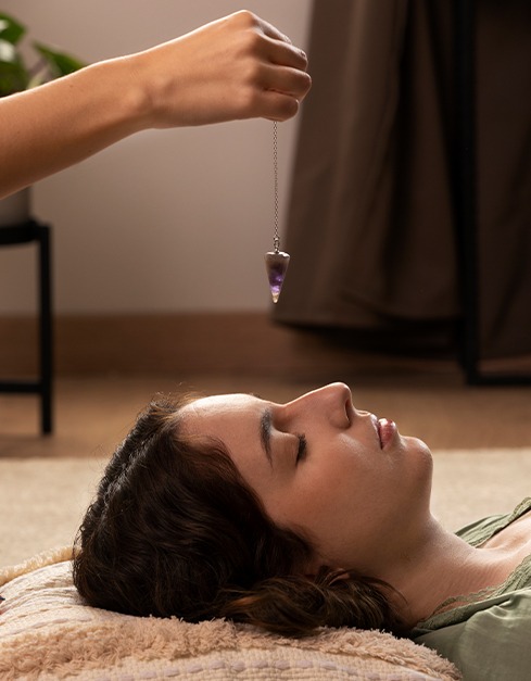Crystal pendulum used in energy healing session